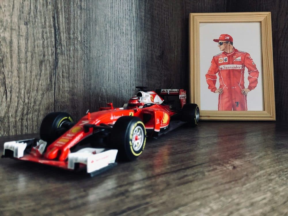 Red and black Formula 1 scale model on a wooden shelf