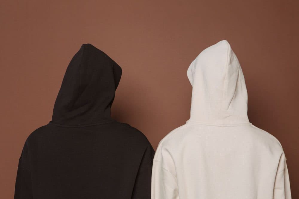 Black hoodie seen from behind next to a white hoodie