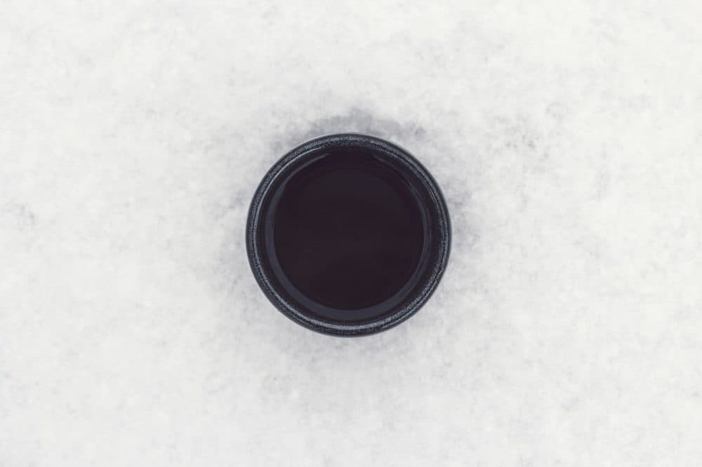 Top view of a black mug of coffee on white
