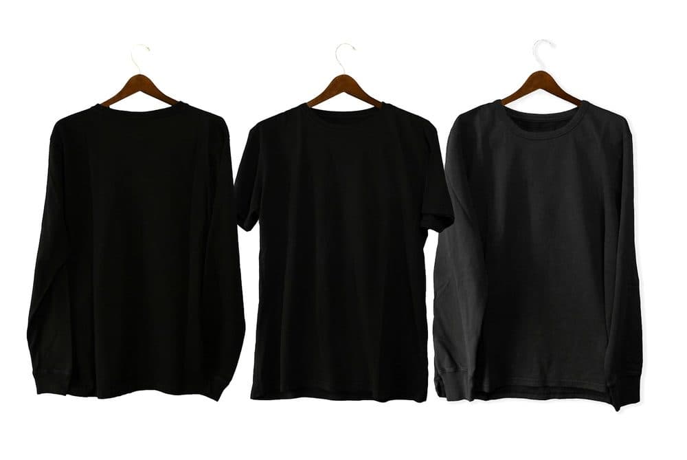 Black crew-neck t-shirts on wooden hangers
