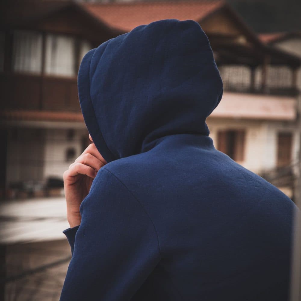 Back view of a navy hoodie with the hood up