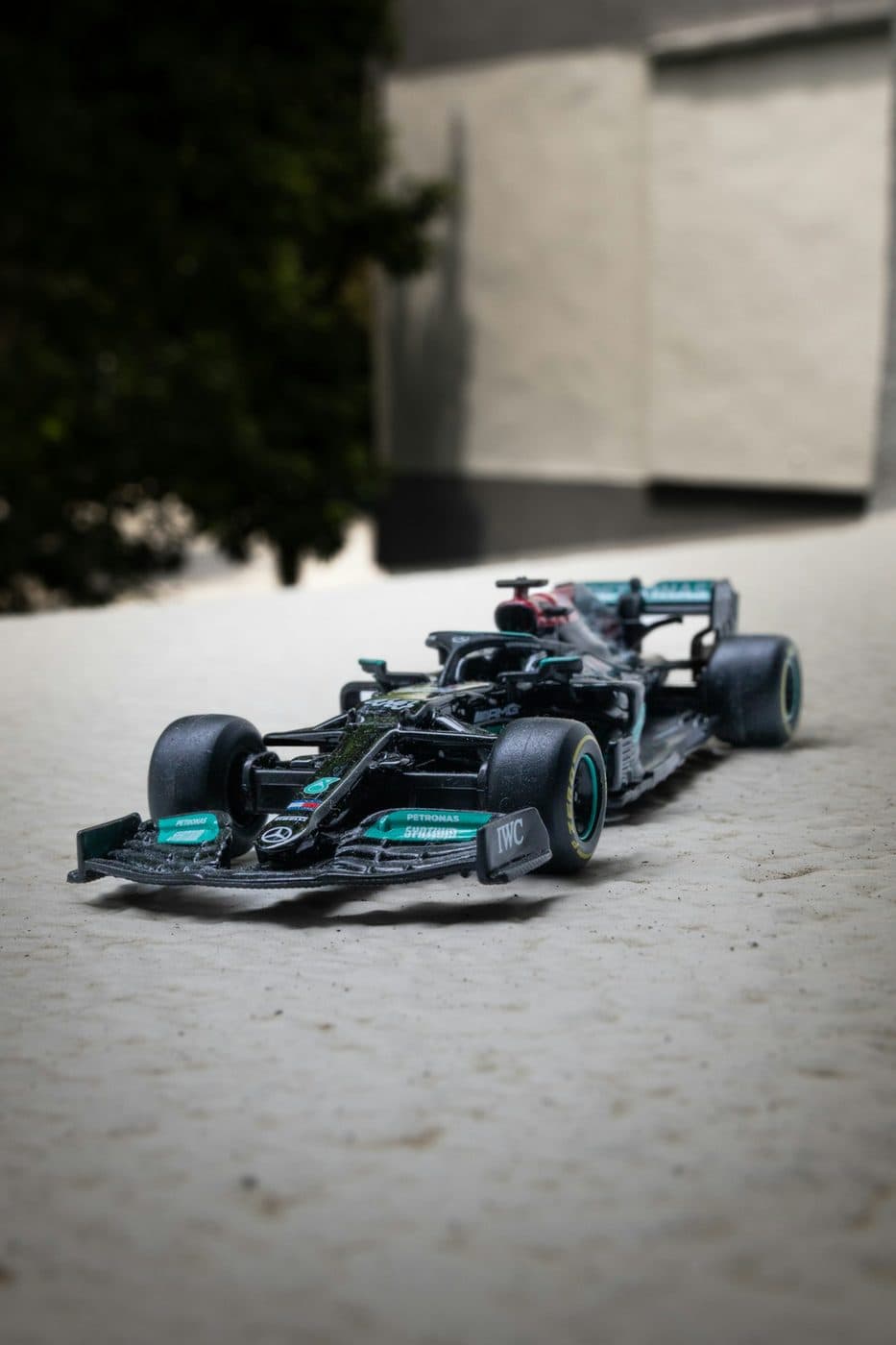 Black Formula 1 scale model car on a textured surface