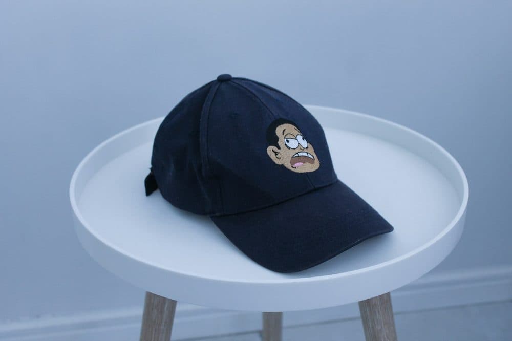 Navy six-panel baseball cap on a white side table